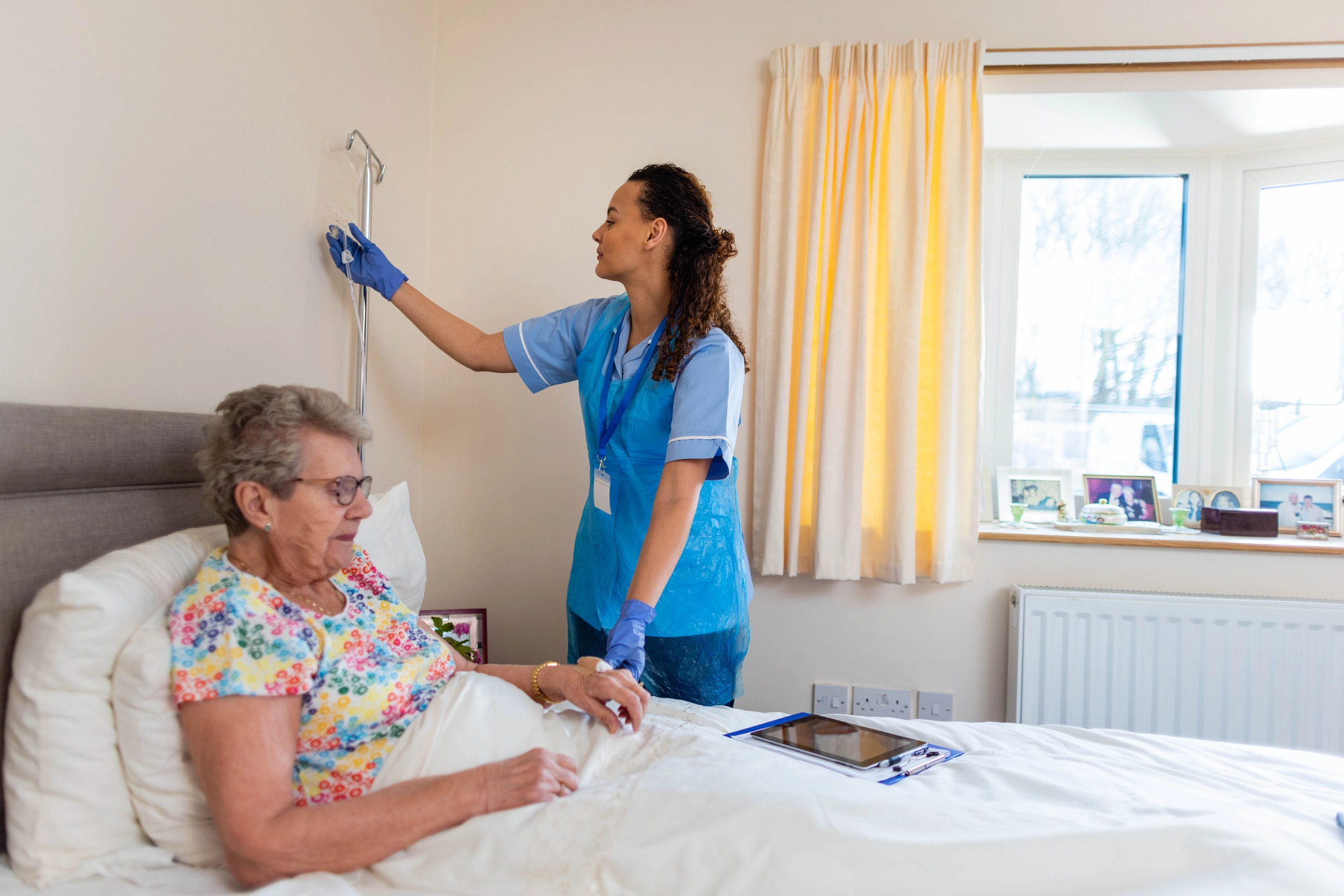 Clinician checks on an older adult at home while reviewing medications.