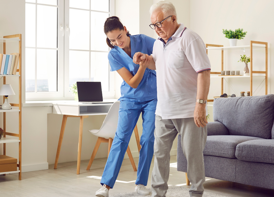 Nurse supports an older adult during a short walk at home.